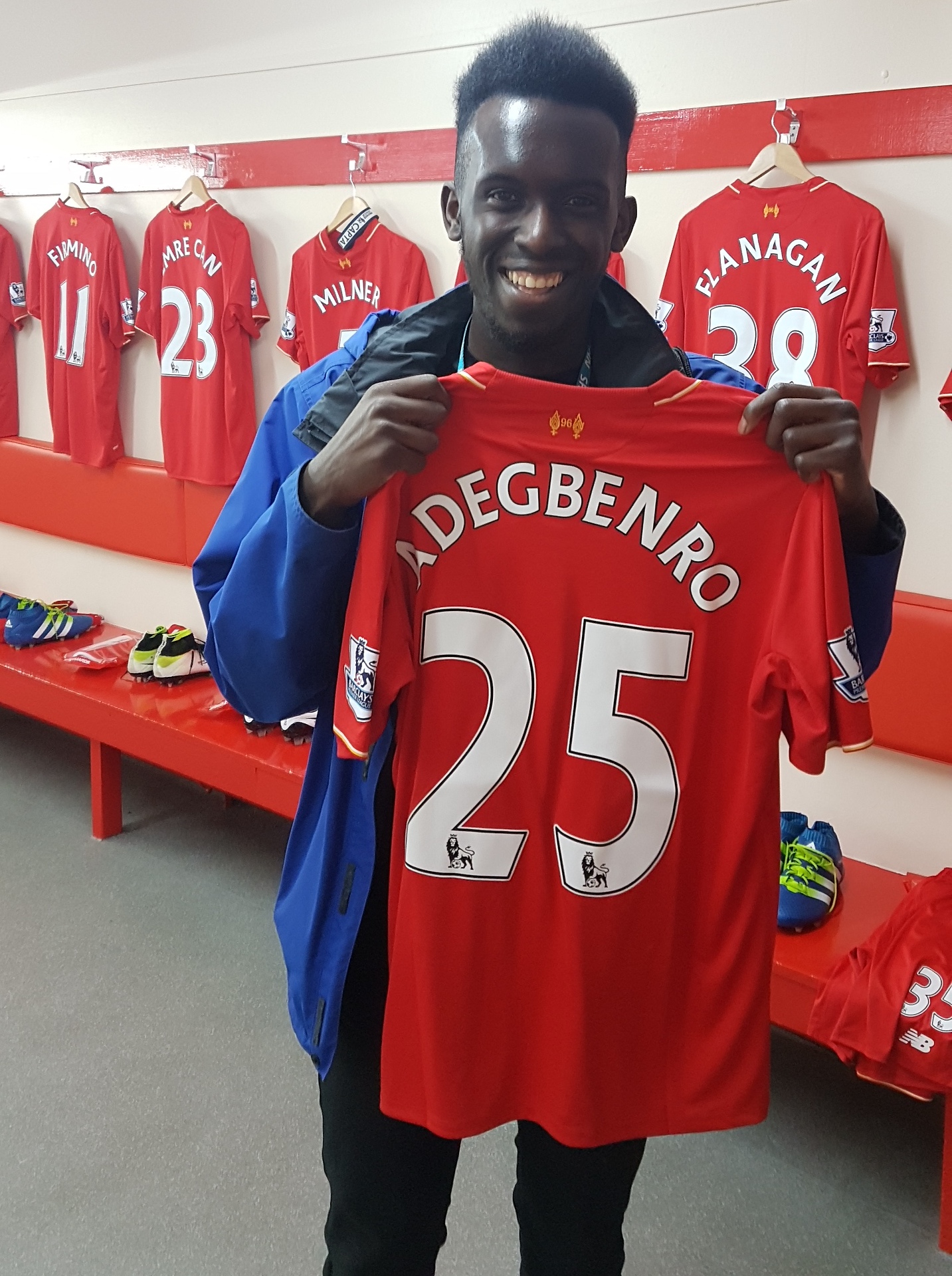 Emini holding up a Liverpool FC shirt
